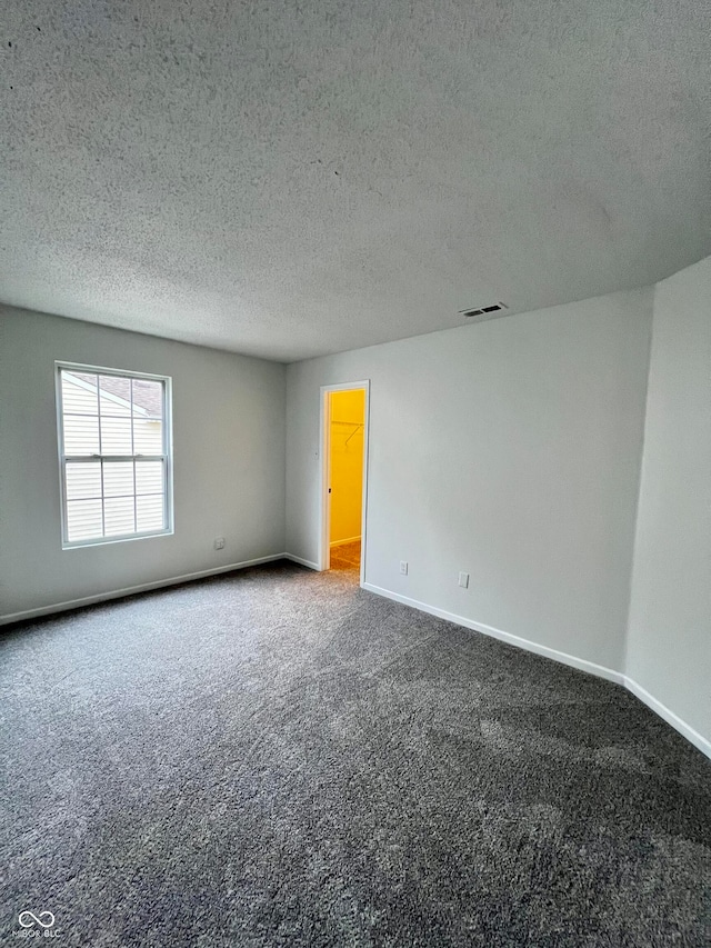 spare room with carpet flooring and a textured ceiling