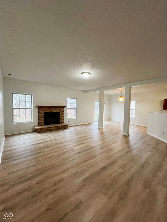 unfurnished living room with a fireplace, hardwood / wood-style floors, and a textured ceiling