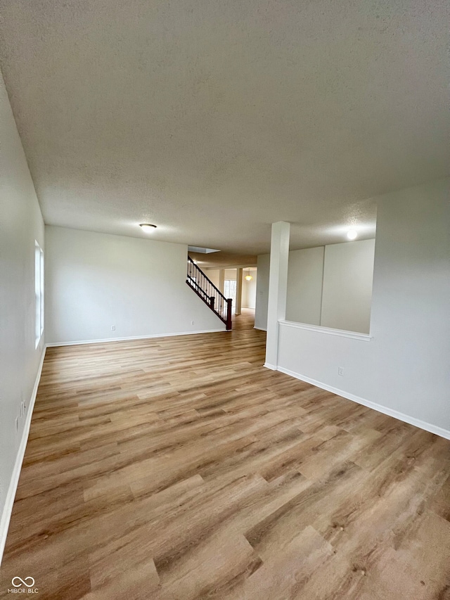 basement with light hardwood / wood-style floors and a textured ceiling