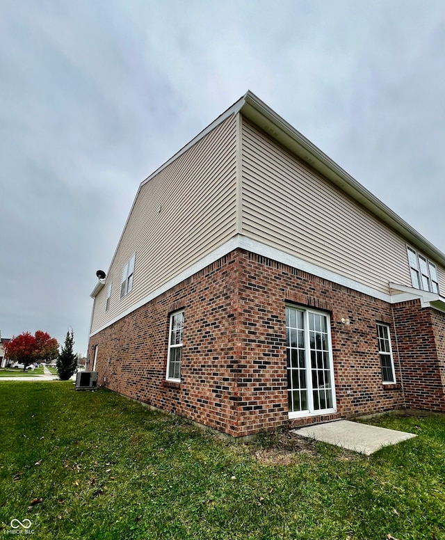 view of property exterior featuring central air condition unit, a patio, and a yard