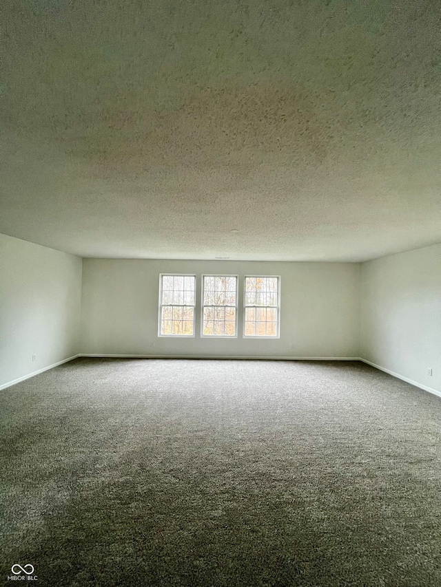 spare room featuring carpet flooring and a textured ceiling