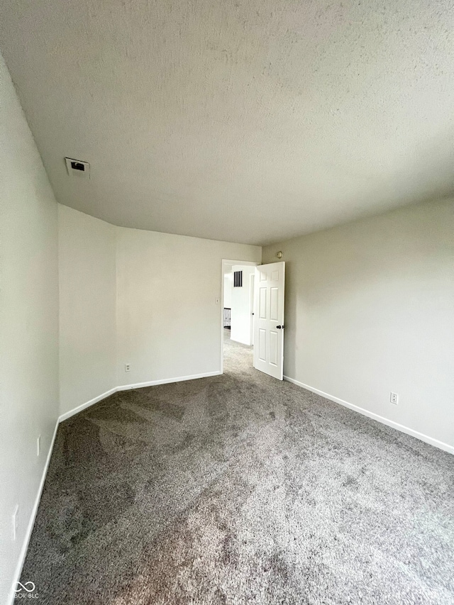 unfurnished room featuring carpet flooring and a textured ceiling