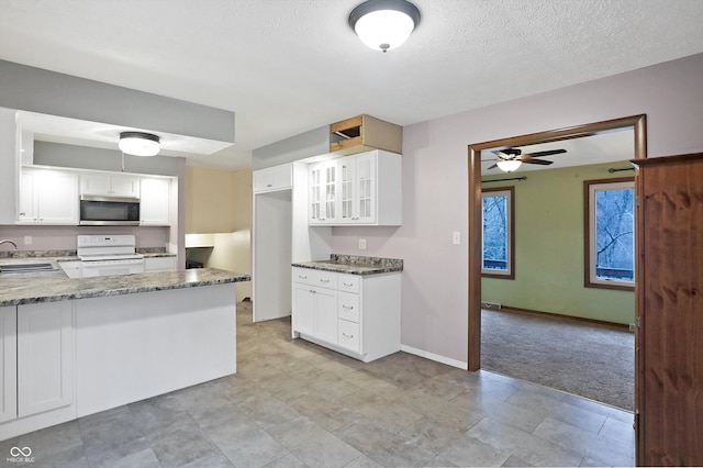 kitchen featuring white range, light colored carpet, sink, stone counters, and white cabinetry