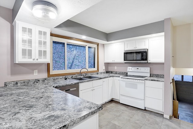 kitchen with white cabinets, stainless steel appliances, light stone countertops, and sink