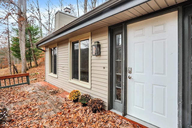 view of exterior entry with a wooden deck