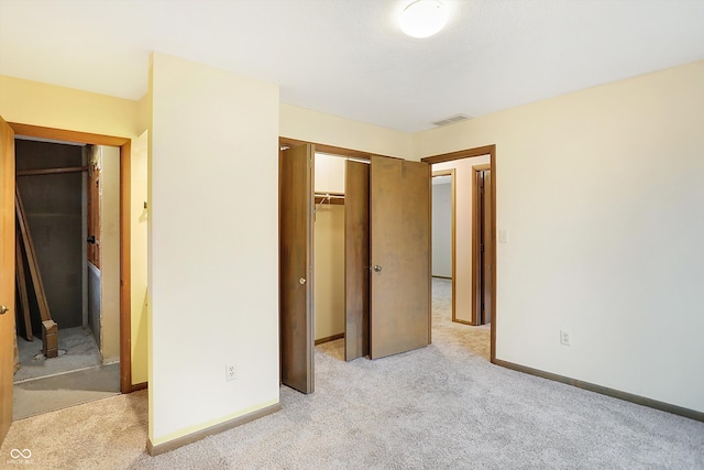 unfurnished bedroom with light carpet and a closet