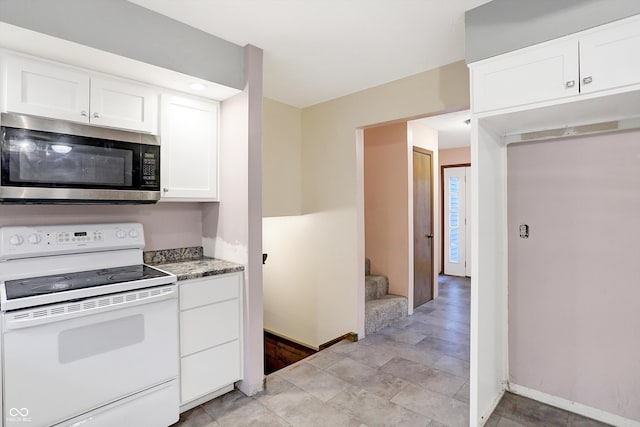 kitchen with white cabinets, light stone countertops, and electric stove