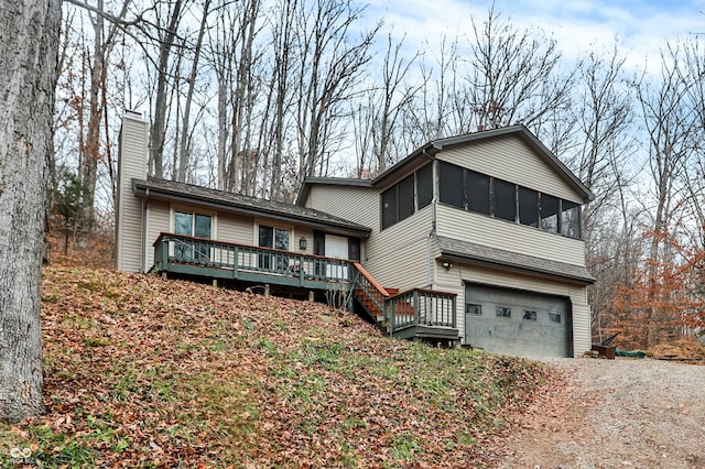 view of front of home with a sunroom, a garage, and a deck