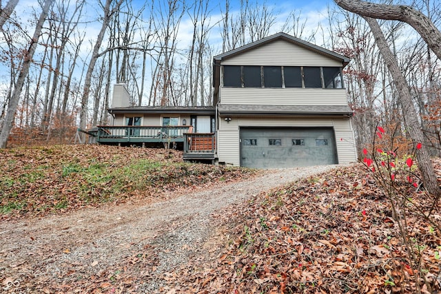 view of front of home with a sunroom, a deck, and a garage