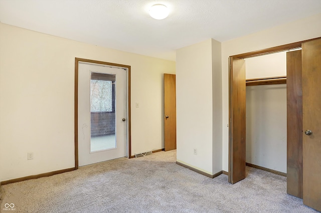 unfurnished bedroom with light carpet and a closet