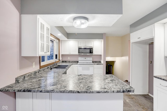 kitchen featuring white range with electric stovetop, kitchen peninsula, white cabinetry, and sink