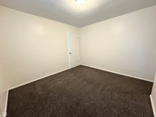 spare room featuring dark carpet