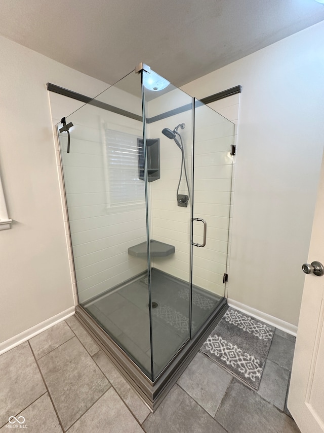 bathroom with tile patterned flooring and a shower with door