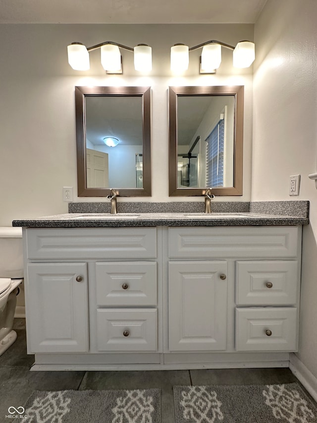 bathroom featuring tile patterned flooring, vanity, and toilet