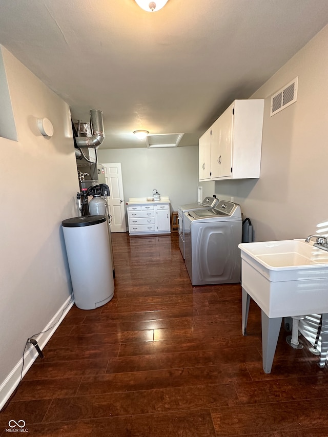 washroom with cabinets, dark hardwood / wood-style floors, and washer and clothes dryer