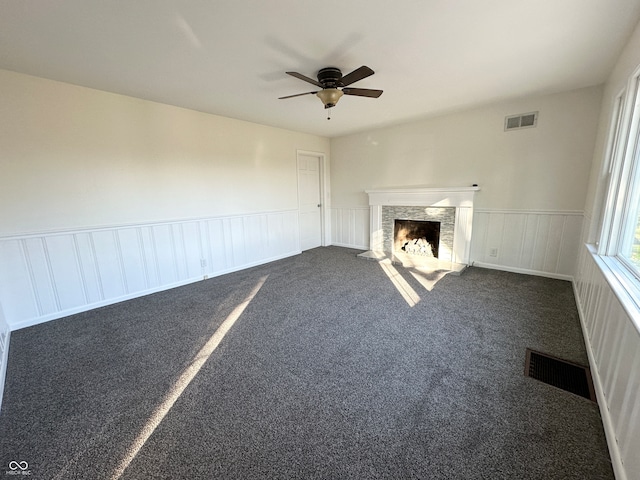 unfurnished living room featuring ceiling fan and dark carpet