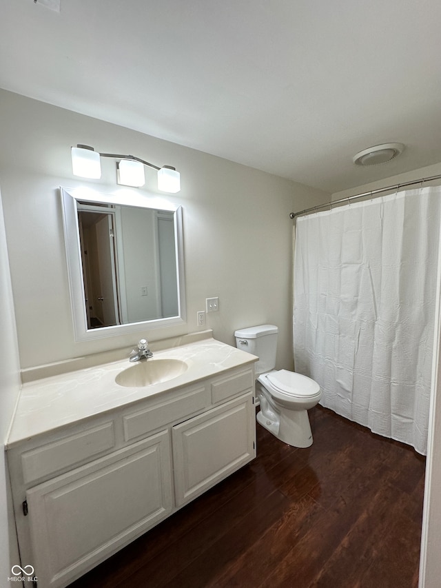 bathroom with hardwood / wood-style floors, vanity, and toilet