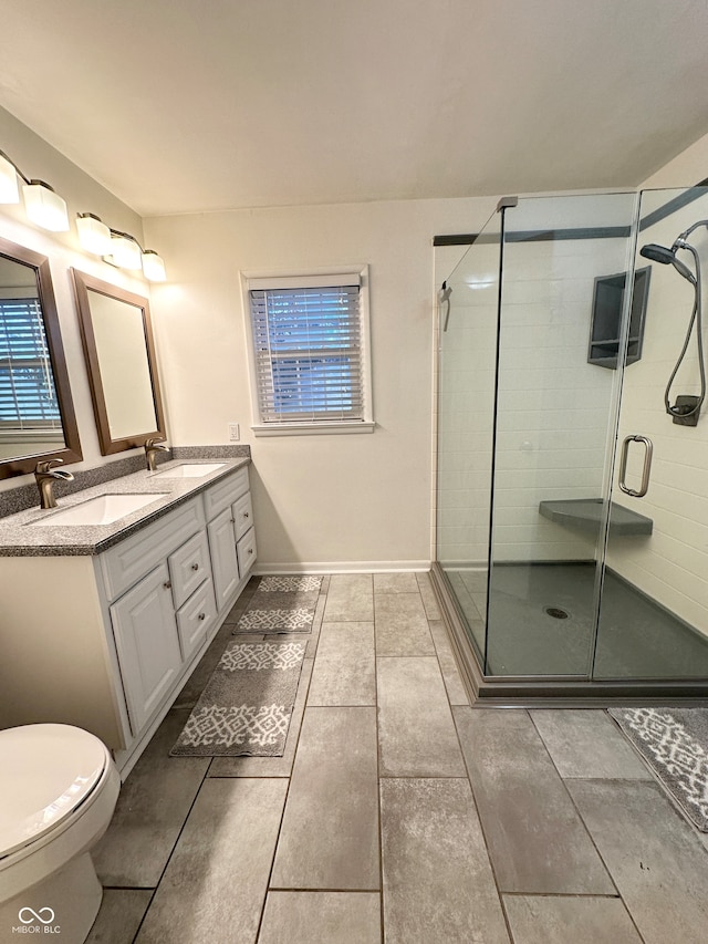 bathroom with toilet, vanity, and walk in shower