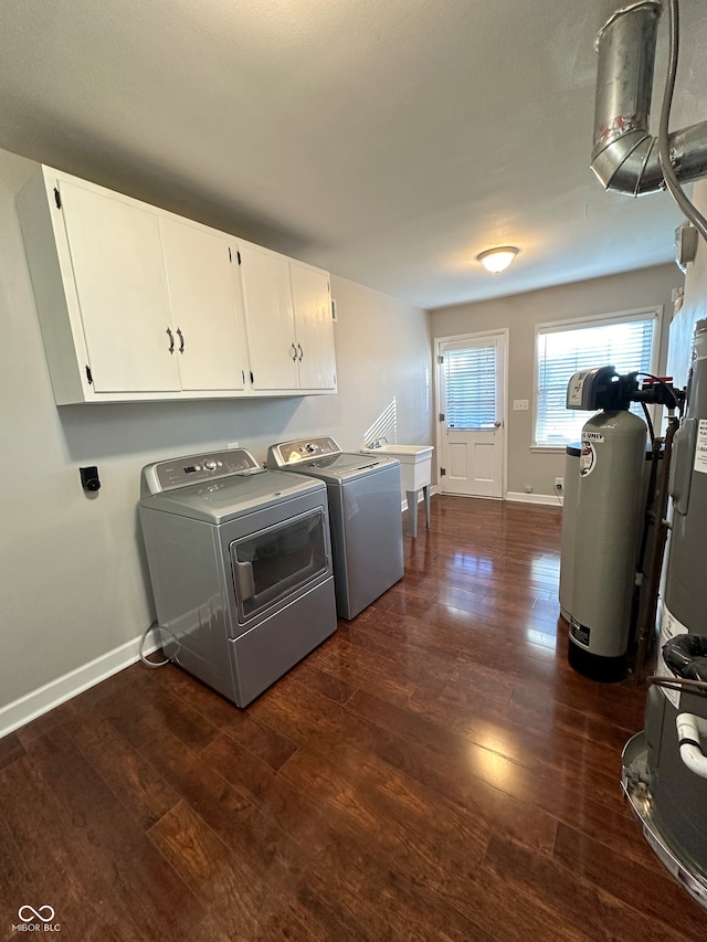 clothes washing area featuring sink, washer and dryer, cabinets, and dark wood-type flooring