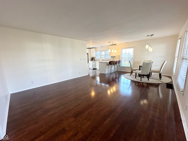 living room featuring dark hardwood / wood-style flooring, an inviting chandelier, and sink