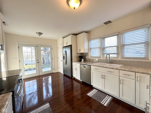 kitchen featuring a wealth of natural light, sink, white cabinets, and appliances with stainless steel finishes