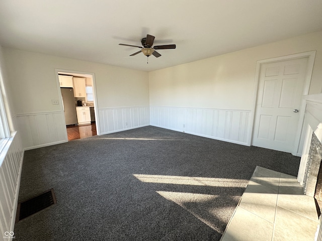 spare room with dark colored carpet and ceiling fan