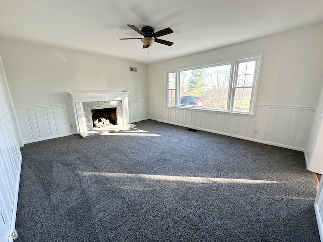 unfurnished living room featuring dark colored carpet and ceiling fan