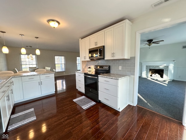 kitchen featuring white cabinets, decorative backsplash, stainless steel appliances, and hanging light fixtures