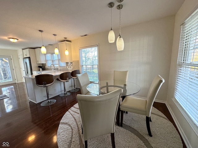 dining room with dark hardwood / wood-style flooring and sink