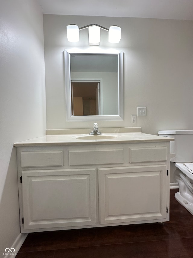 bathroom featuring vanity, wood-type flooring, and toilet