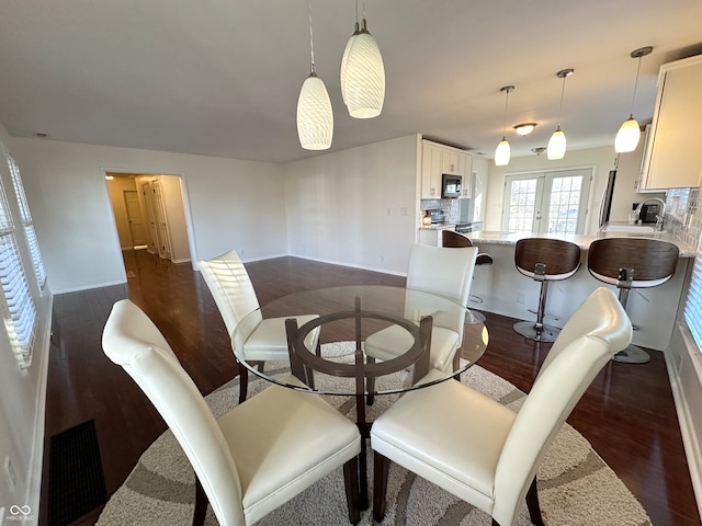 dining room with french doors, dark hardwood / wood-style flooring, and sink