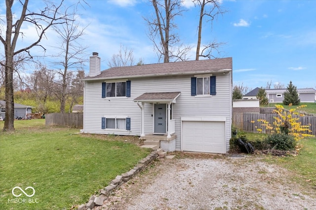 split foyer home featuring a front yard and a garage