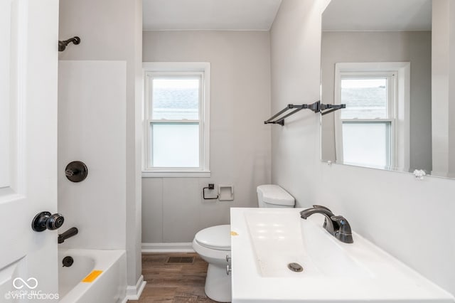 full bathroom with hardwood / wood-style flooring, toilet, shower / bathtub combination, and a healthy amount of sunlight