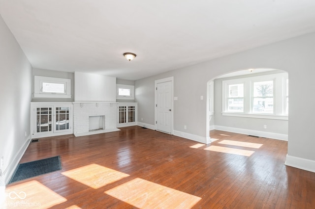 unfurnished living room featuring a fireplace and wood-type flooring