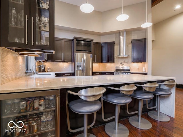 kitchen with wall chimney range hood, sink, wine cooler, dark hardwood / wood-style flooring, and stainless steel appliances