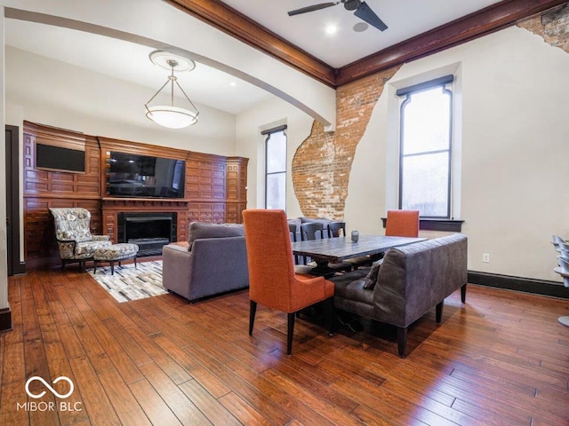 dining room with ceiling fan, a fireplace, and hardwood / wood-style flooring