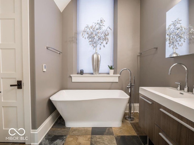 bathroom featuring a bathing tub, vanity, and vaulted ceiling