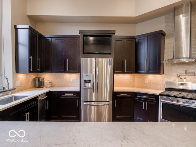 kitchen with wall chimney exhaust hood, sink, stainless steel appliances, and tasteful backsplash