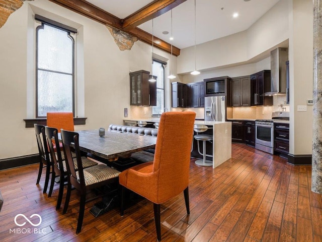 dining area featuring beamed ceiling and dark hardwood / wood-style floors