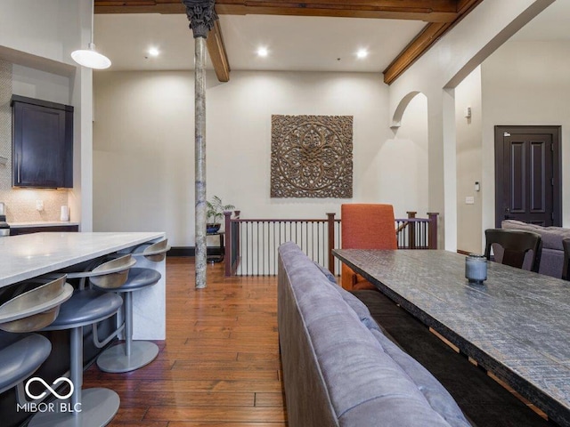 dining space with beamed ceiling and dark hardwood / wood-style floors