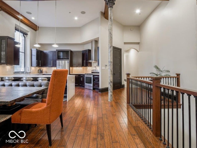 dining area featuring sink, dark wood-type flooring, and a high ceiling