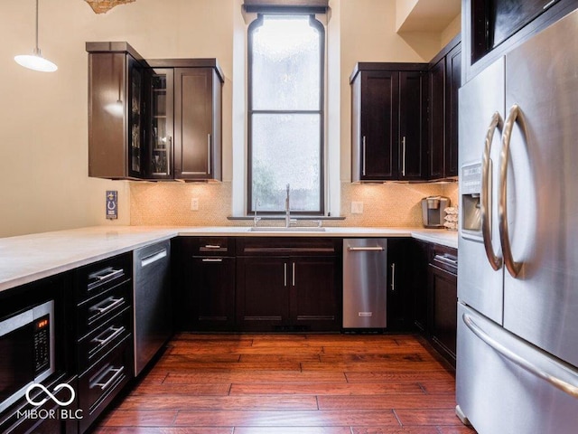 kitchen with sink, dark hardwood / wood-style flooring, pendant lighting, and appliances with stainless steel finishes