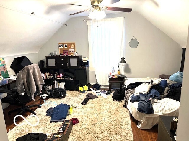 bedroom with dark wood-type flooring, ceiling fan, and lofted ceiling