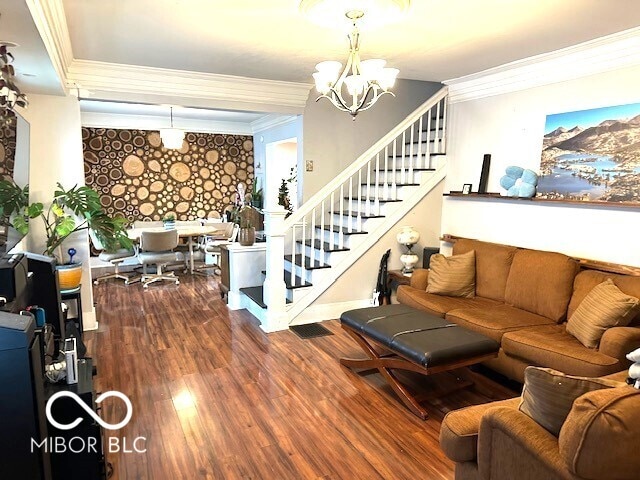 living room with crown molding, hardwood / wood-style floors, and an inviting chandelier