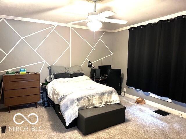 carpeted bedroom with ceiling fan and crown molding