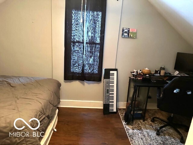 bedroom with vaulted ceiling and dark wood-type flooring