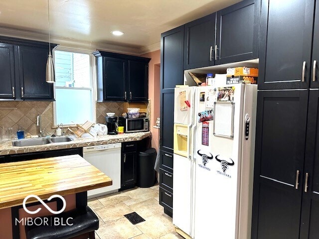 kitchen featuring decorative backsplash, sink, hanging light fixtures, and white appliances