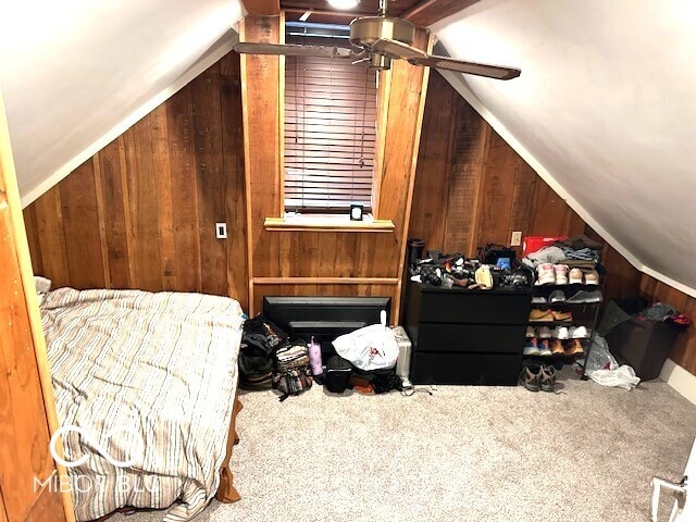 carpeted bedroom featuring wood walls and vaulted ceiling