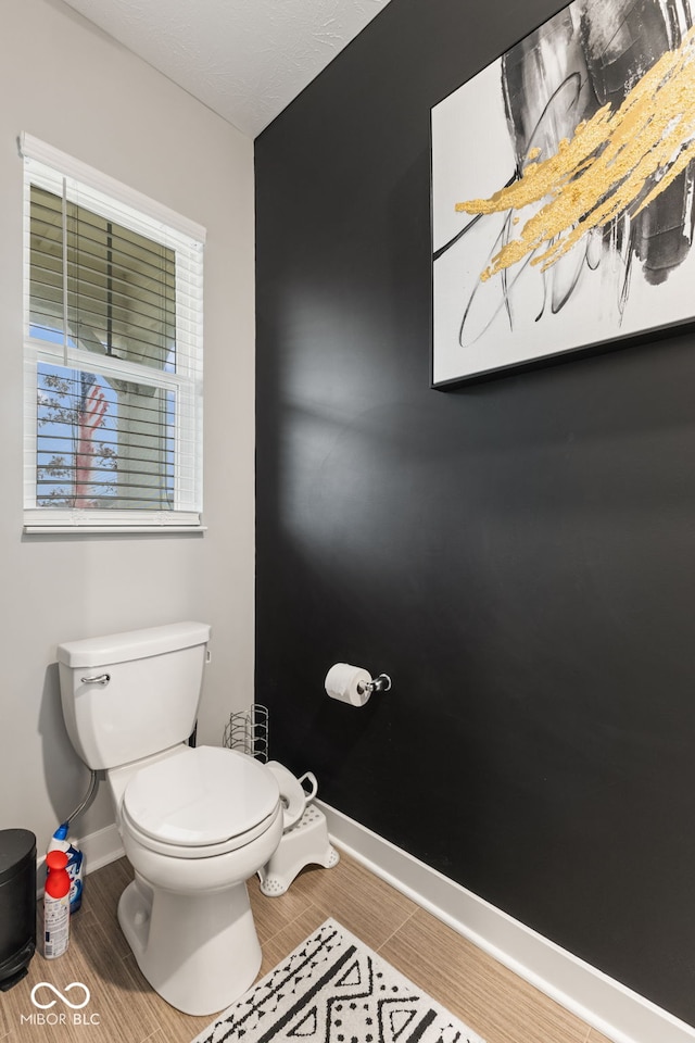 bathroom featuring hardwood / wood-style flooring and toilet