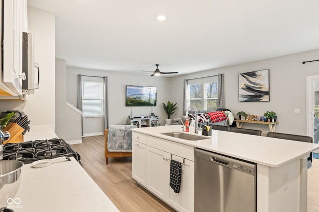 kitchen featuring ceiling fan, stainless steel appliances, light hardwood / wood-style flooring, a kitchen island with sink, and white cabinets